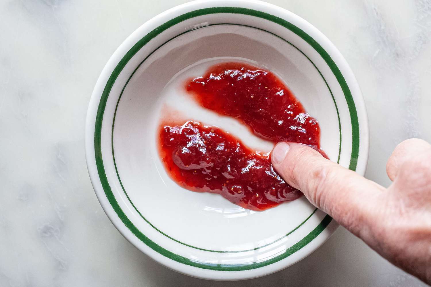 Testing Consistency of Strawberry Jam in Small Bowl for Canning Recipe 