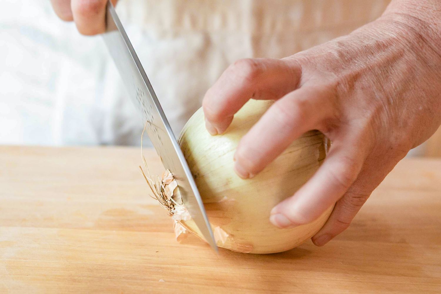 Root End Cut Off Using a Knife With the Other Hand Holding the Onion Firmly on the Cutting Board for How To Chop an Onion