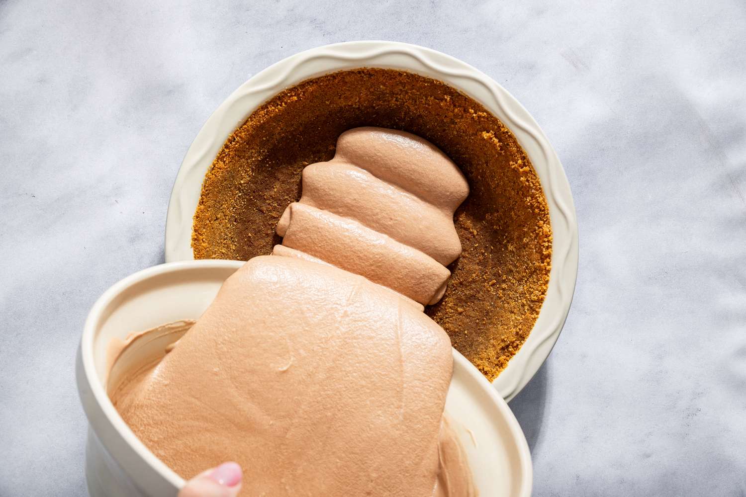 Pouring a creamy filling into a pie crust