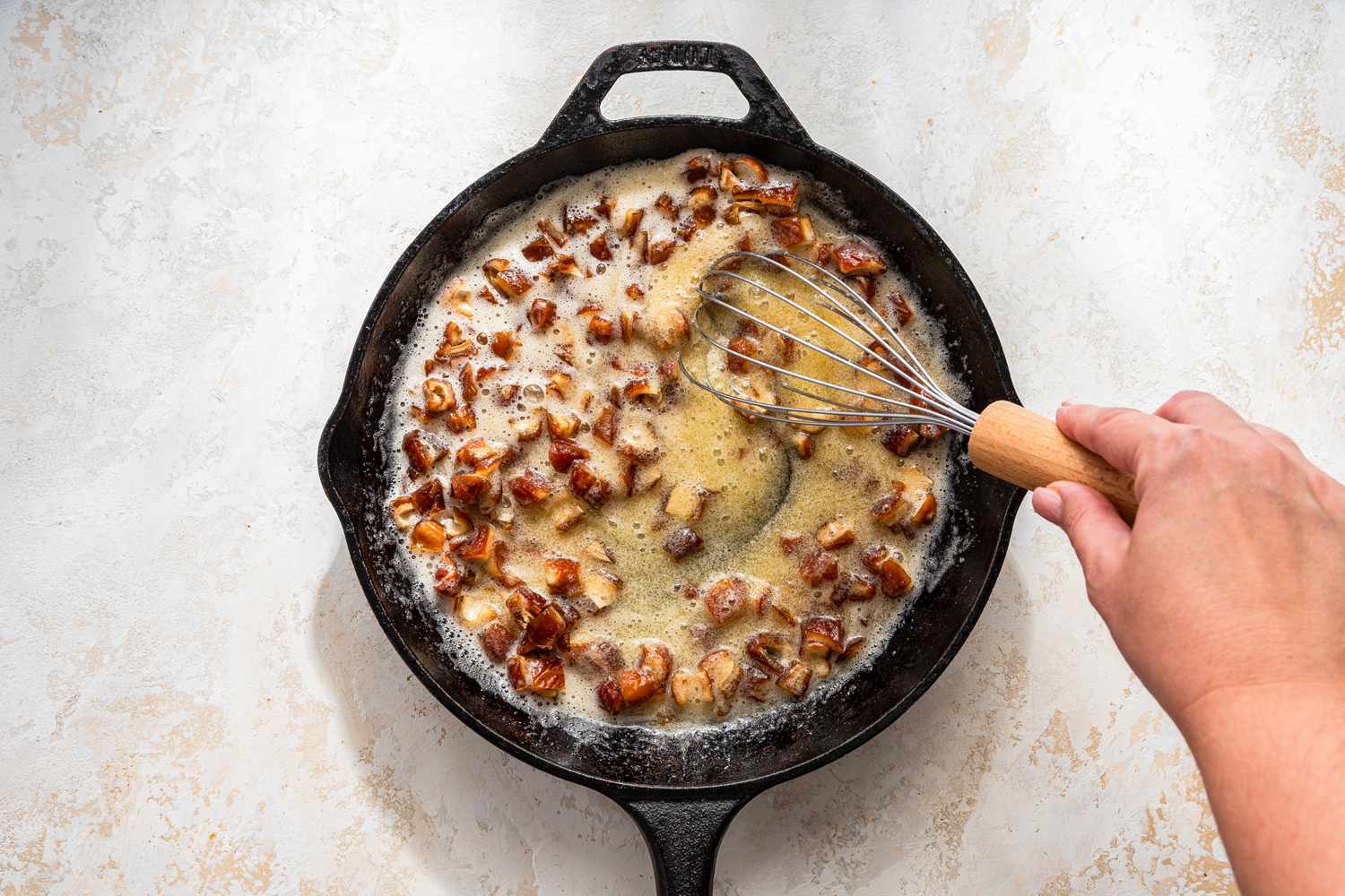 Dates and egg-sugar mixture whisked together in a cast iron skillet