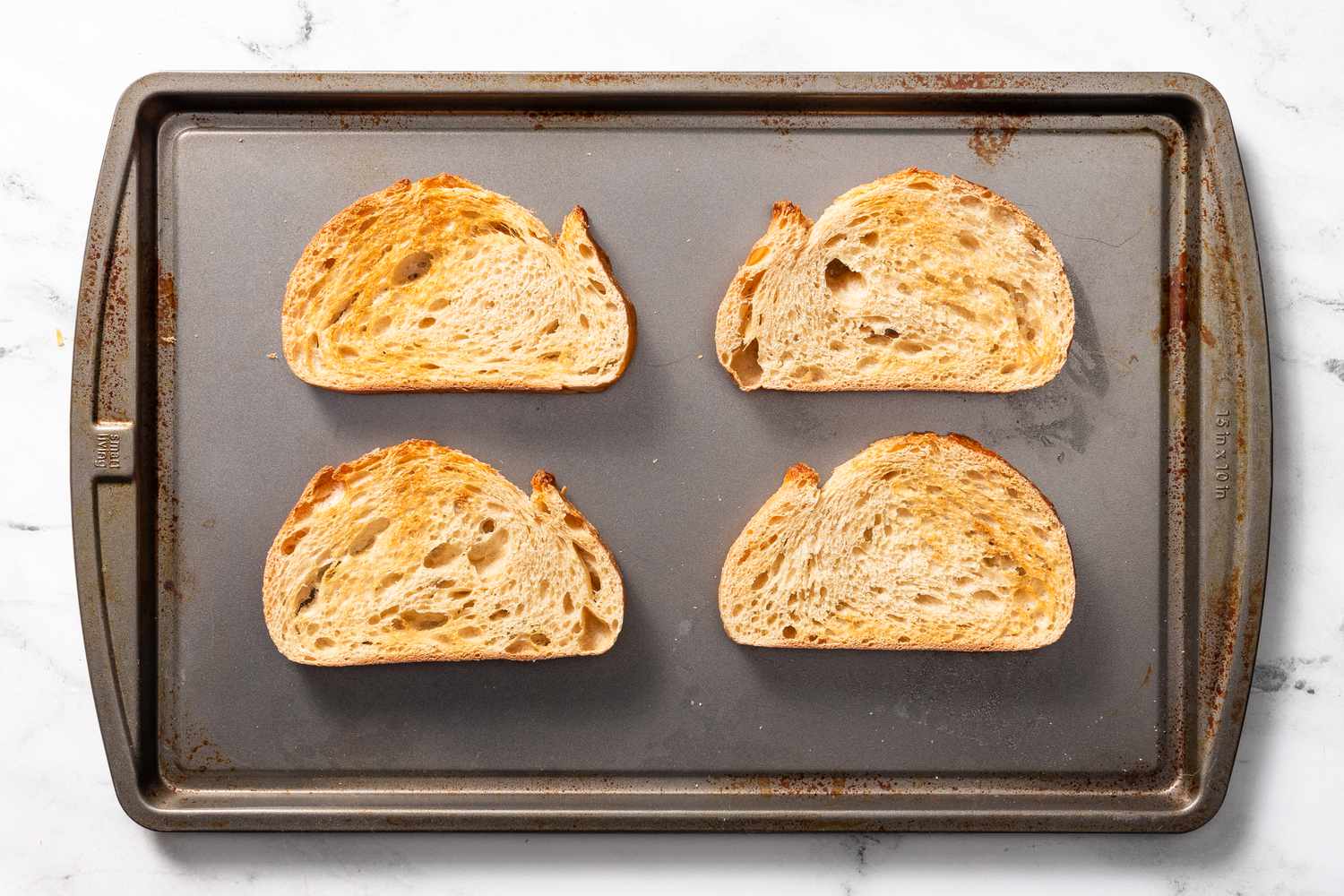 Toasted bread slices on a baking tray for welsh rarebit recipe