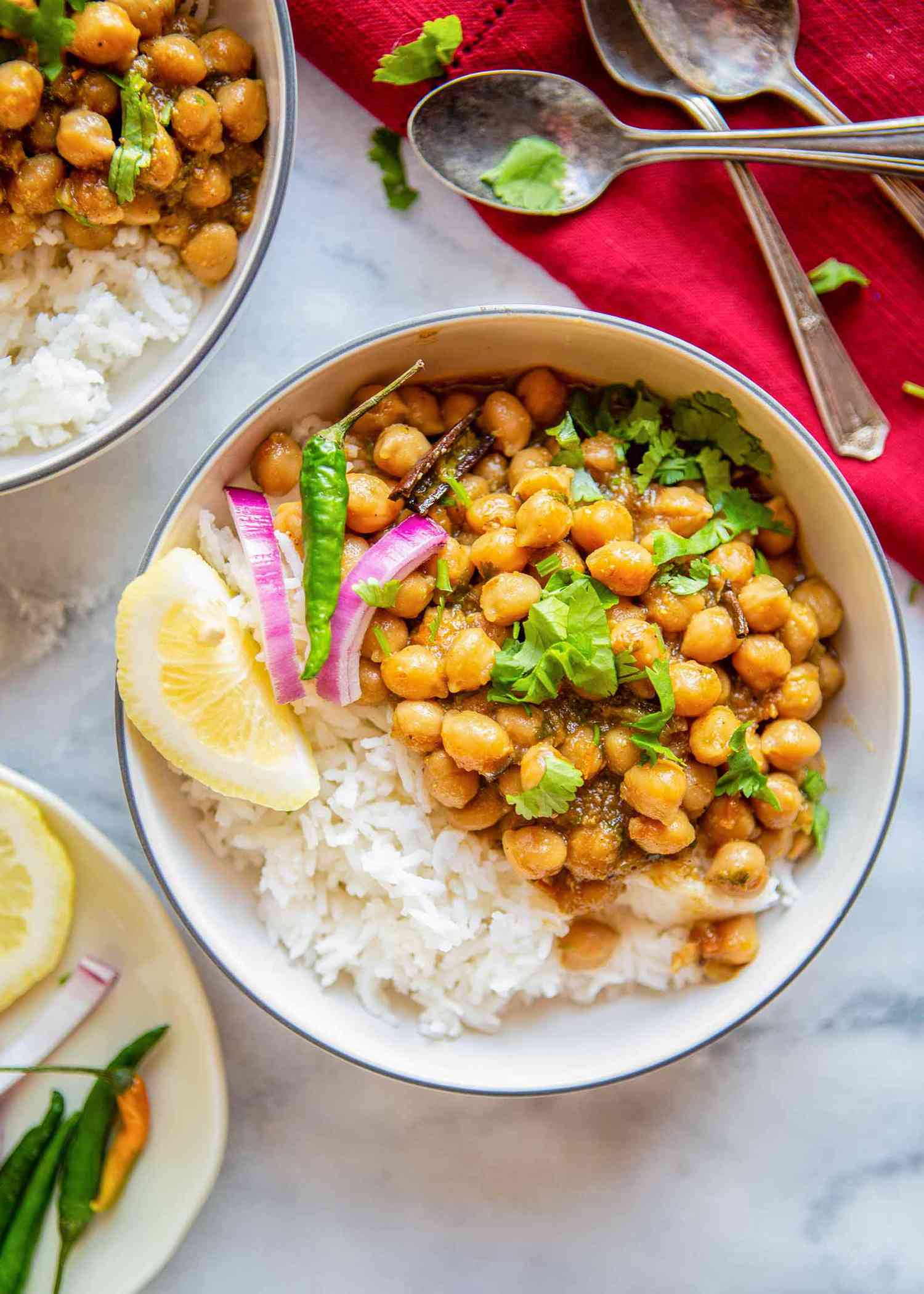 Vegetarian Chana Masala - bowl of chana masala with rice, and lemon wedge