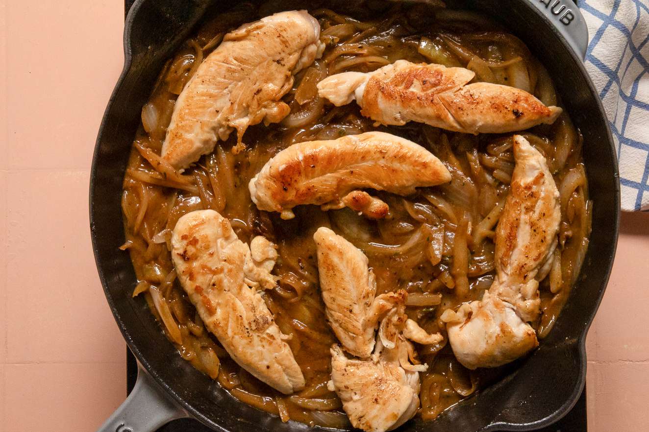 chicken tenderloins added to skillet on top of caramelized onions for french onion chicken recipe