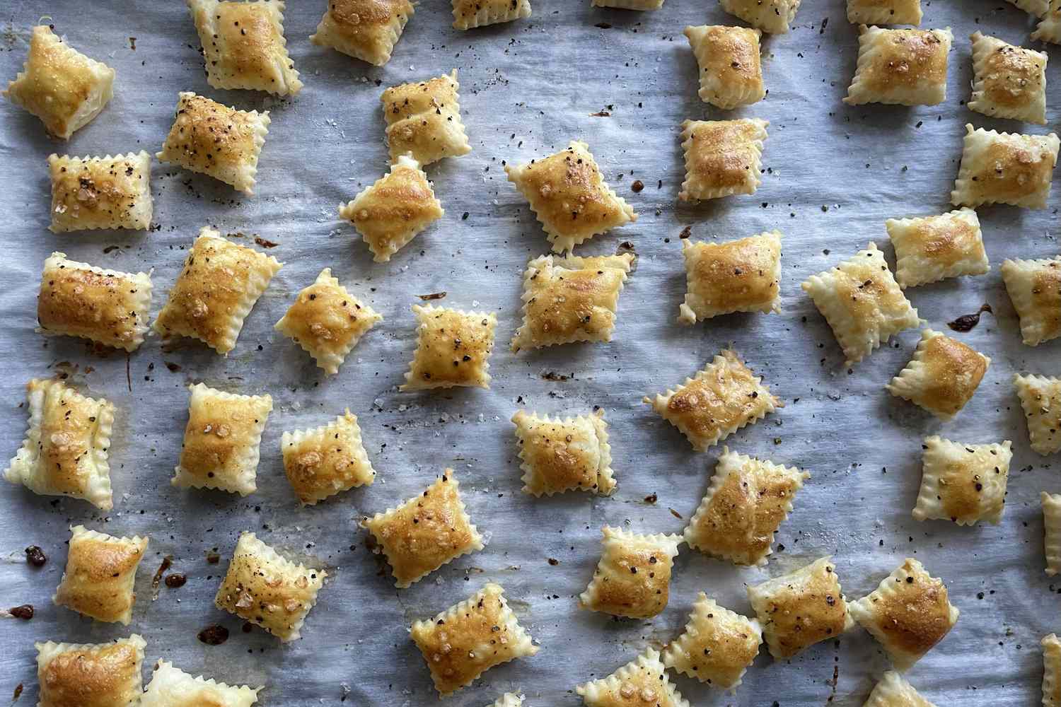 Bitesized golden pastries scattered on a parchmentlined baking sheet