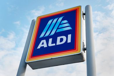 The ALDI store sign against a cloudy sky