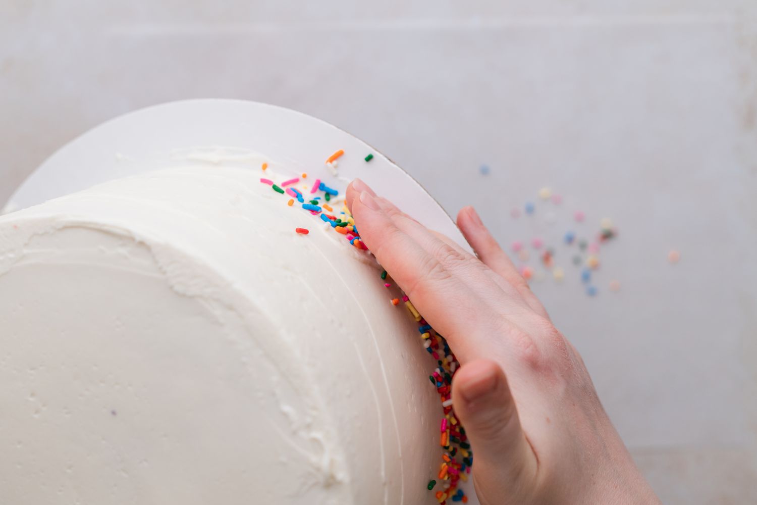 Adding Rainbow Sprinkles to Cake with Rainbow Layers 