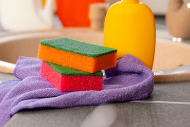 Two kitchen sponges next to a sink