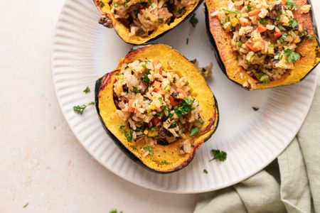 Overhead view of three vegetarian stuffed squash on a platter.