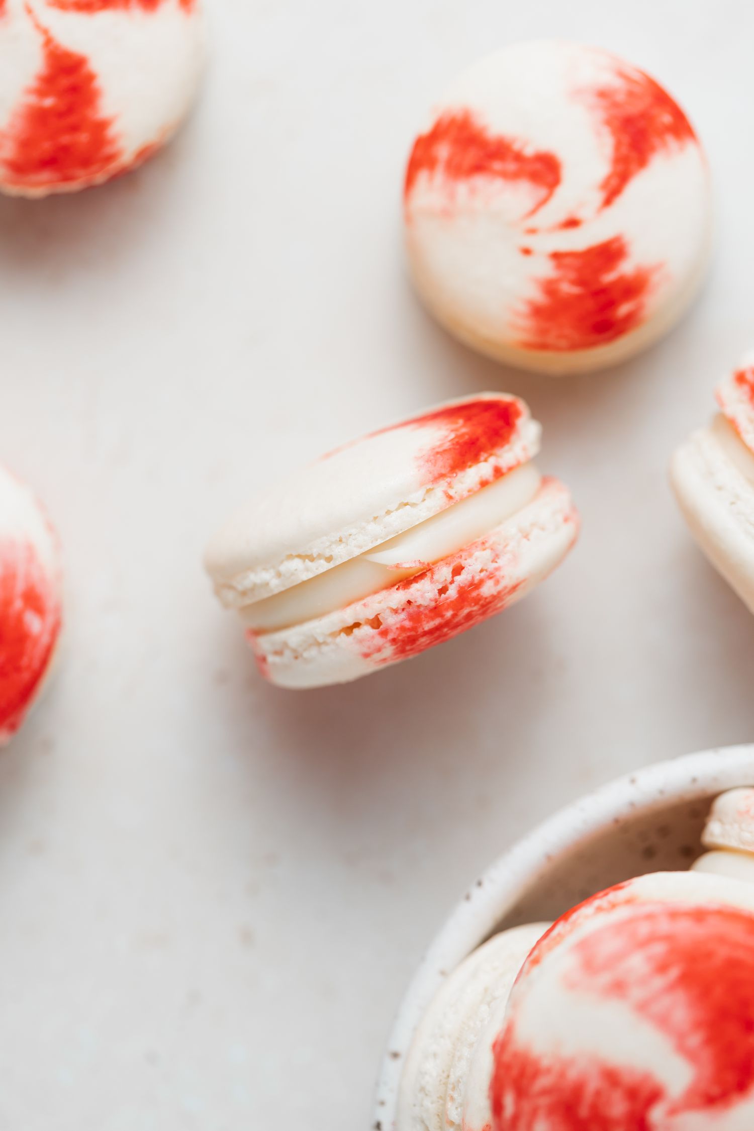 Overhead view of macarons with peppermint and white chocolate fillingset on its side on a white background.