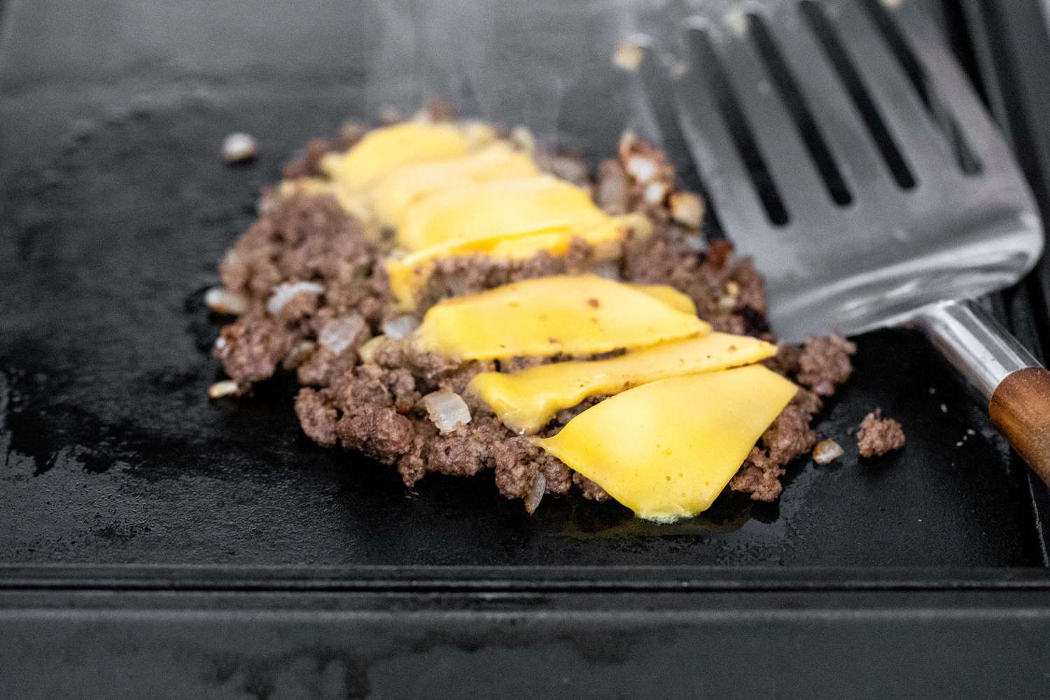 Beef Filling Topped with Slices of Cheese on a Griddle for Chopped Cheese Sandwich 