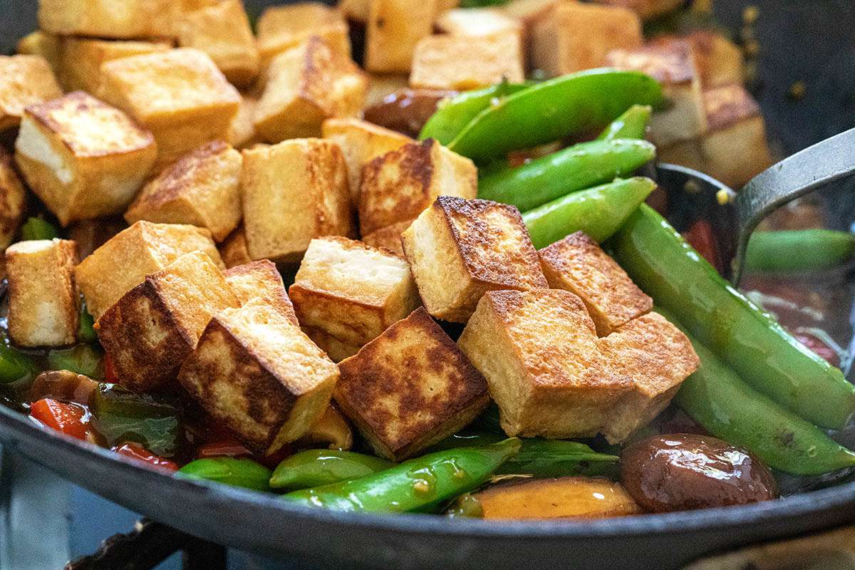 A spoon mixing tofu and vegetables for a Vegetarian Stir Fry with Tofu.