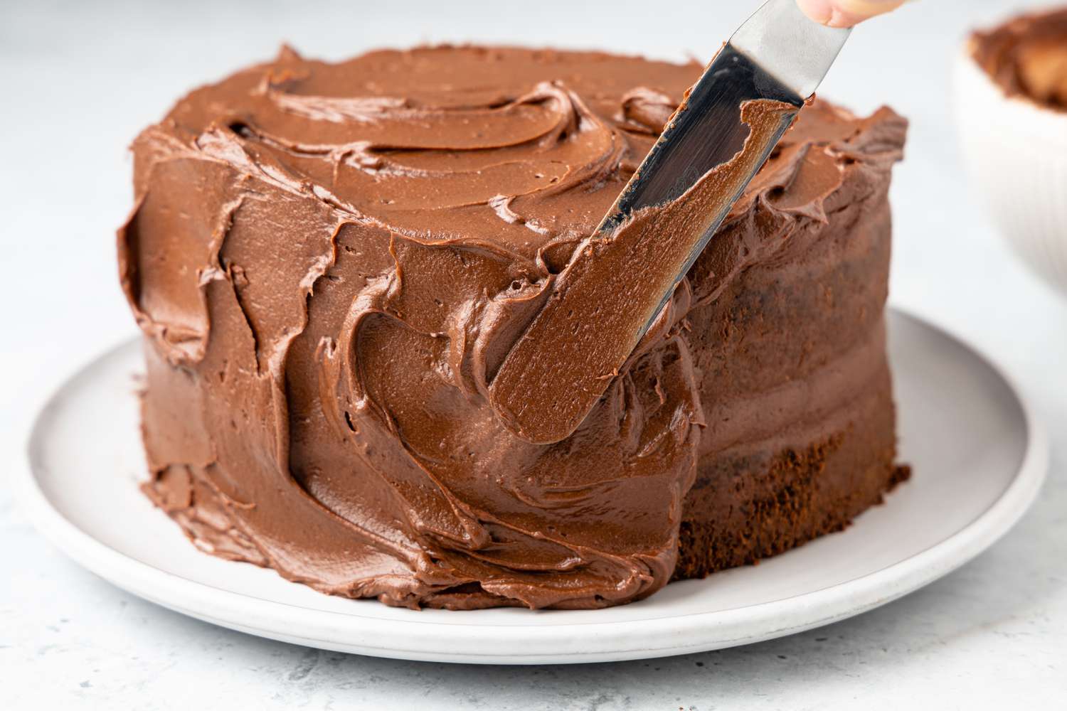 Easy Chocolate Buttercream Frosting Spread onto a Cake Using an Offset Spatula 