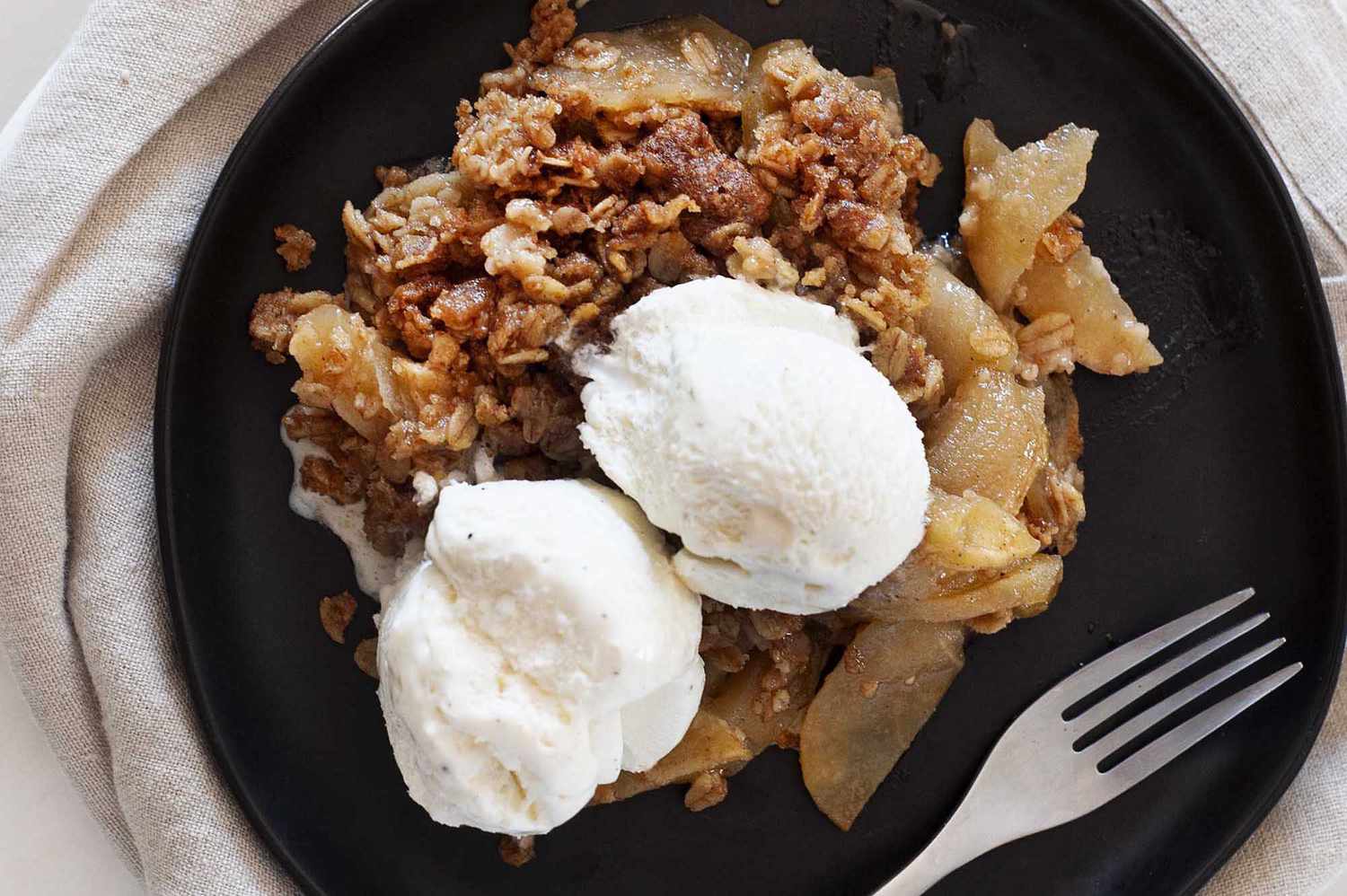 Apple crisp recipe topped with vanilla ice cream.