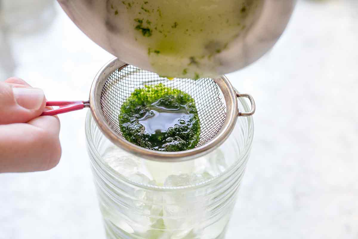 Strain the mint and rum mixture for mojitos into a glass