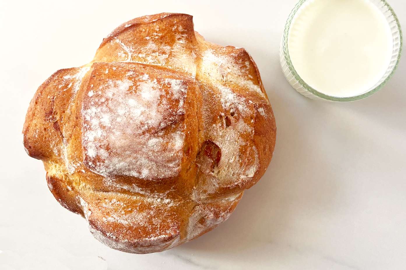 Loaf of bread with a glass of buttermilk next to it