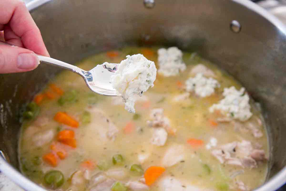 Dumplings spooned onto the top of chicken soup.