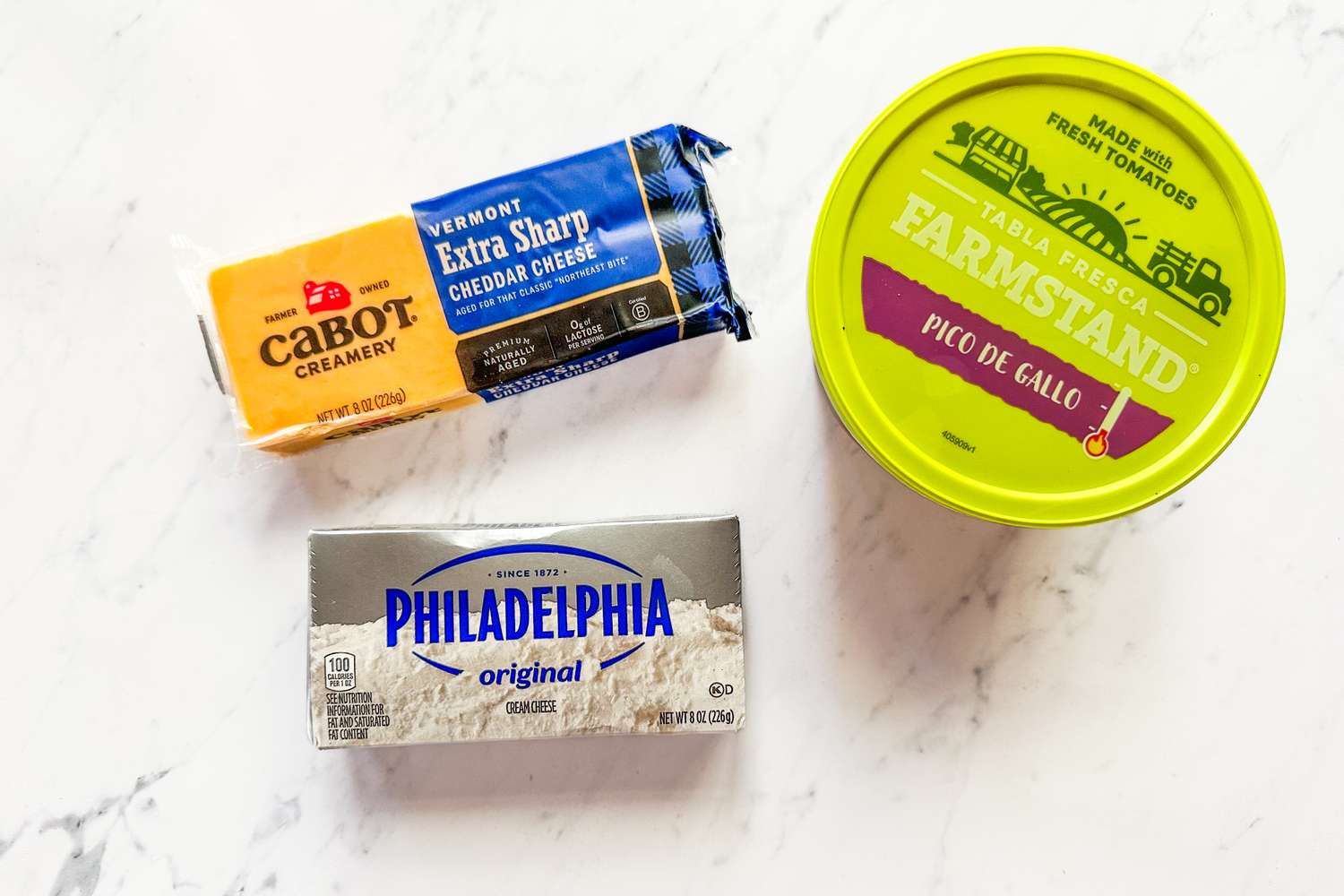 Cabot cheddar cheese Philadelphia cream cheese and Farmstand pico de gallo arranged on a white surface