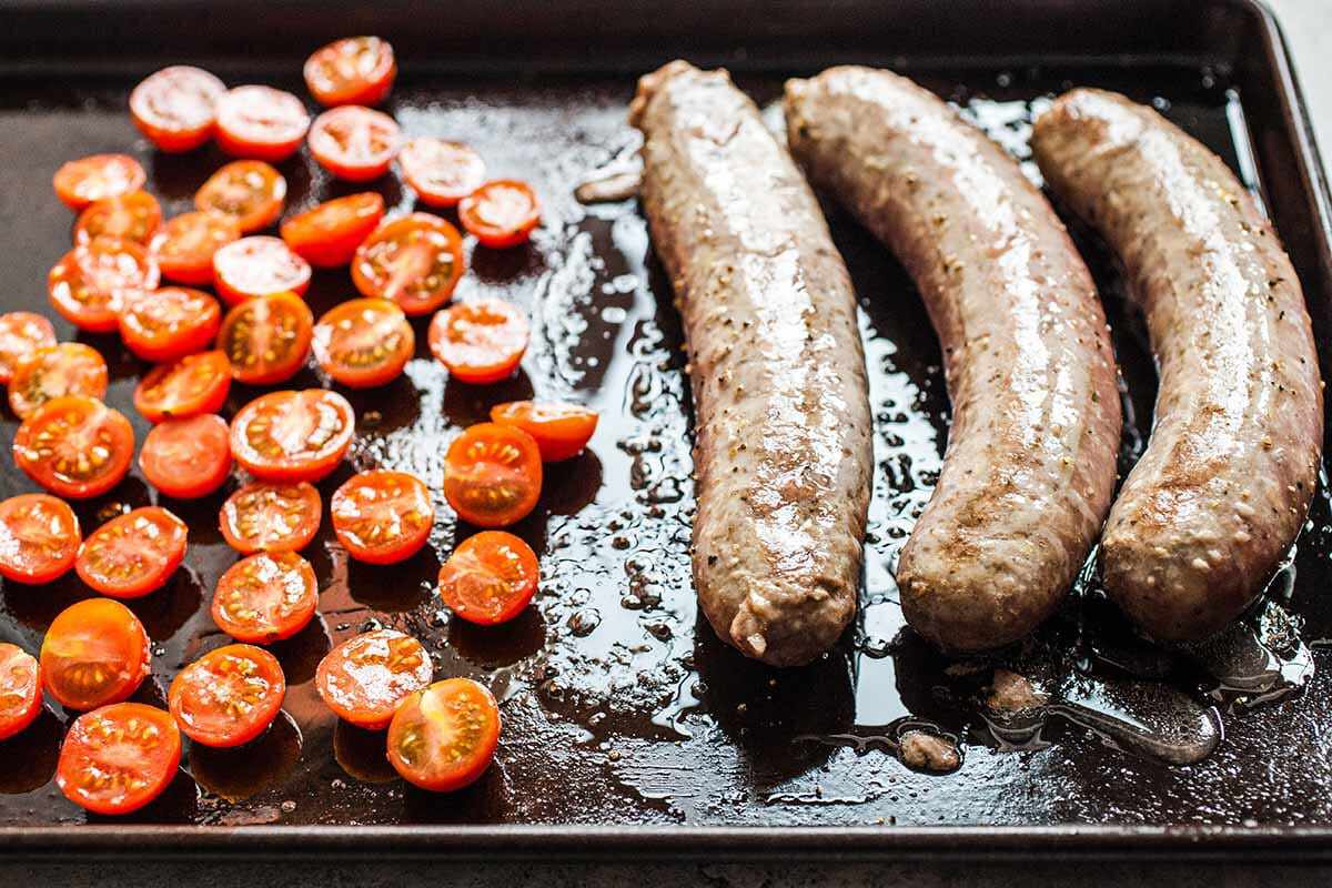 Cooking the sausages and tomatoes for British Breakfast on a sheet pan