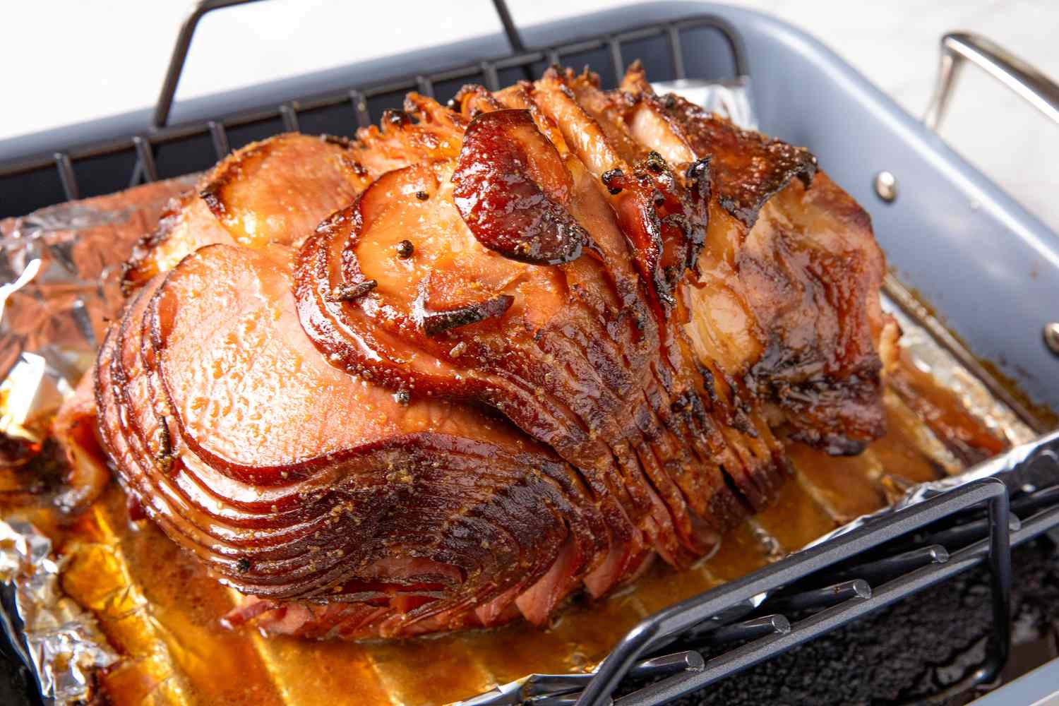 Glazed ham sliced and served in a roasting pan