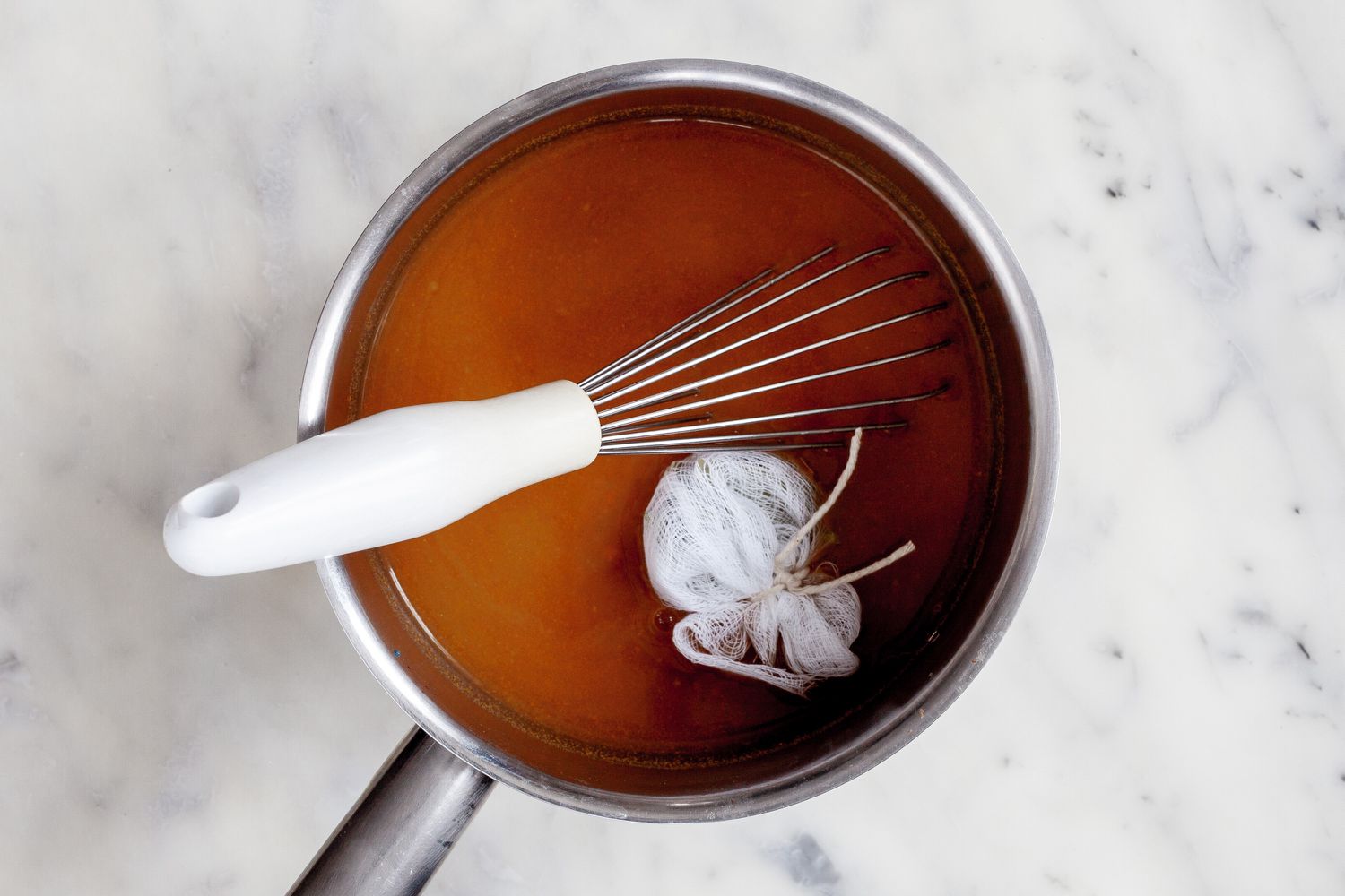 Herb sachet in pot with stock and espagnole sauce for classic demi-glace sauce