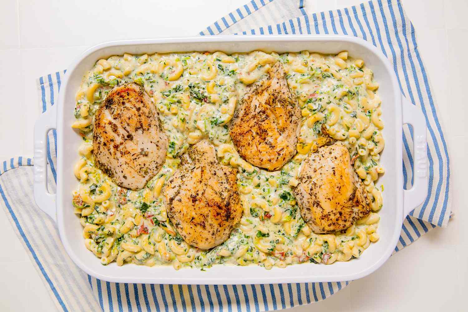 Overhead view of chicken breasts added to the casserole dish for Marry Me Chicken Casserole recipe