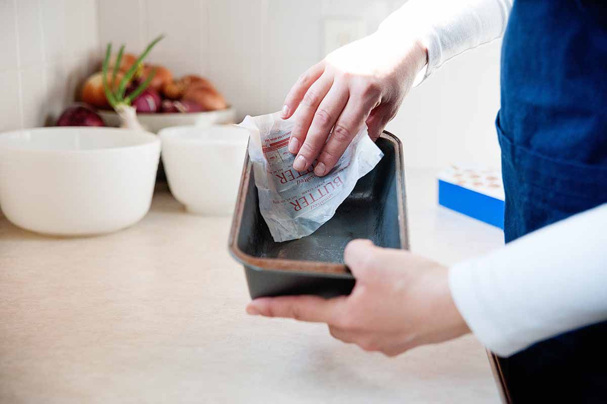 Best Lemon Pound Cake Recipe - rubbing loaf pan with butter