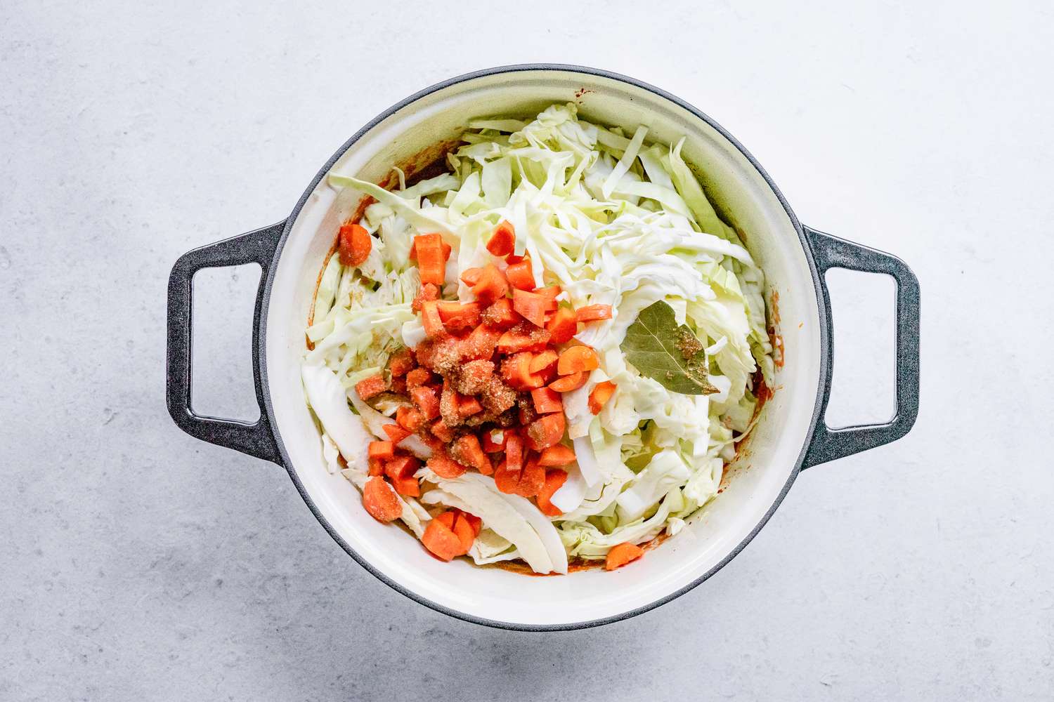 Cabbage, Carrots, Bay Leaf, and Brown Sugar Added to Pot of Sweet and Sour Cabbage Soup
