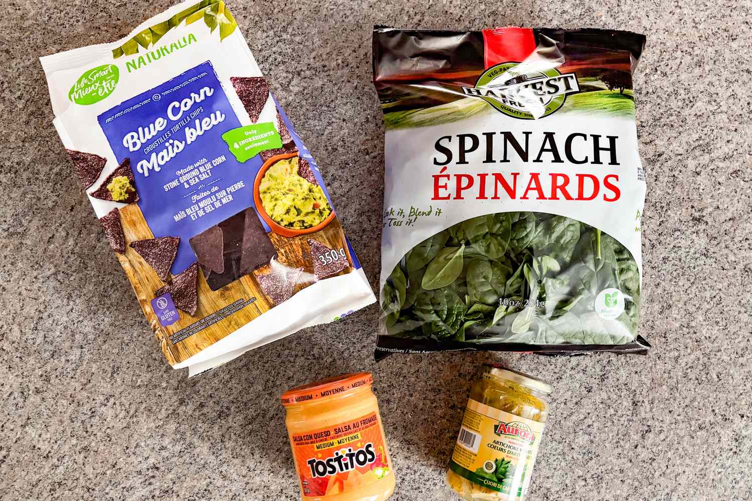 Ingredients including blue corn chips spinach cheese dip and artichoke hearts for Ree Drummond’s 4-Ingredient Artichoke Dip