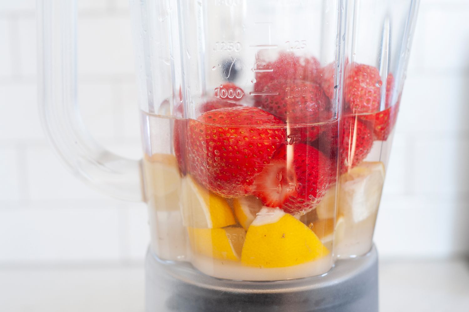 Making homemade strawberry lemonade in a blender.