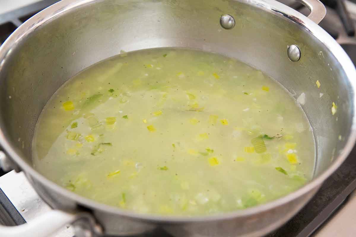 Celery and chicken stock in a soup pot