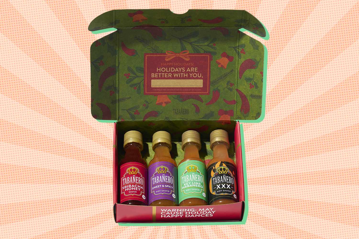 Box containing four small hot sauce bottles with a festive design