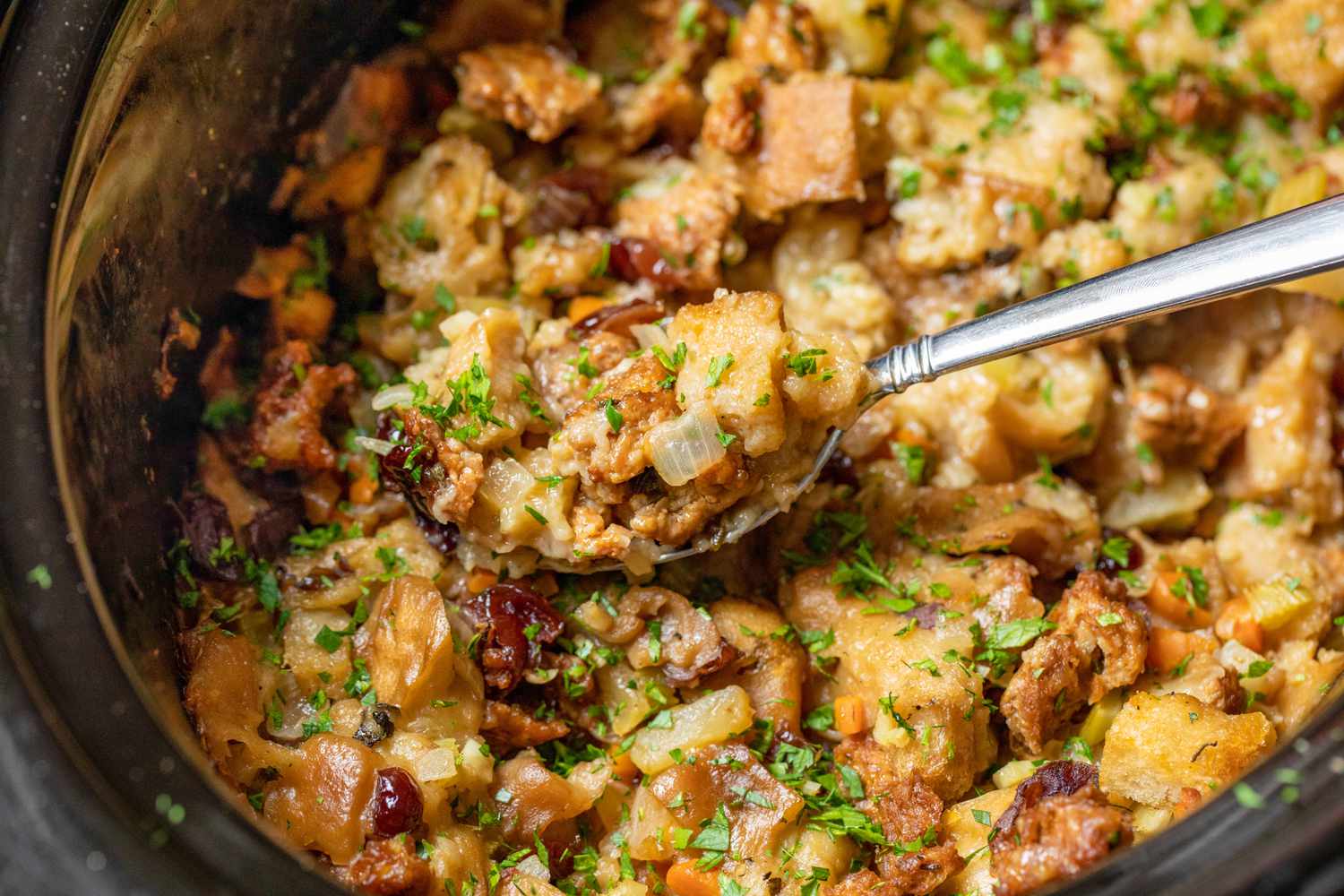 Slow Cooker Stuffing on a Spoon with More in the Background