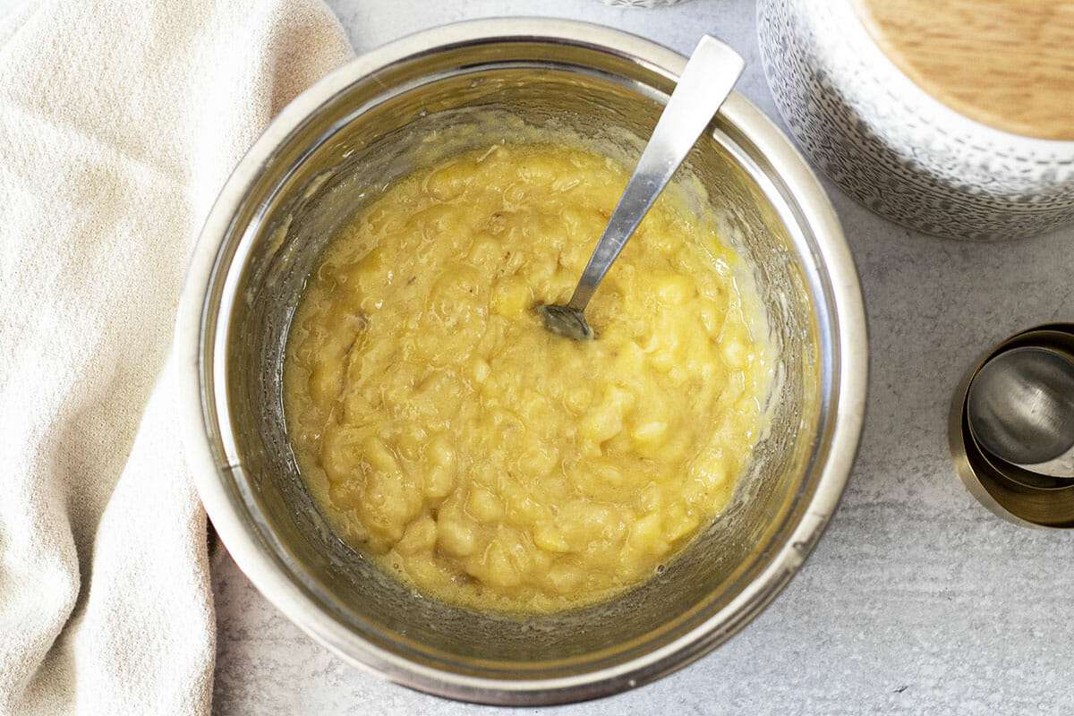 Homemade cream cheeese banana bread recipe being mixed in a metal bowl.