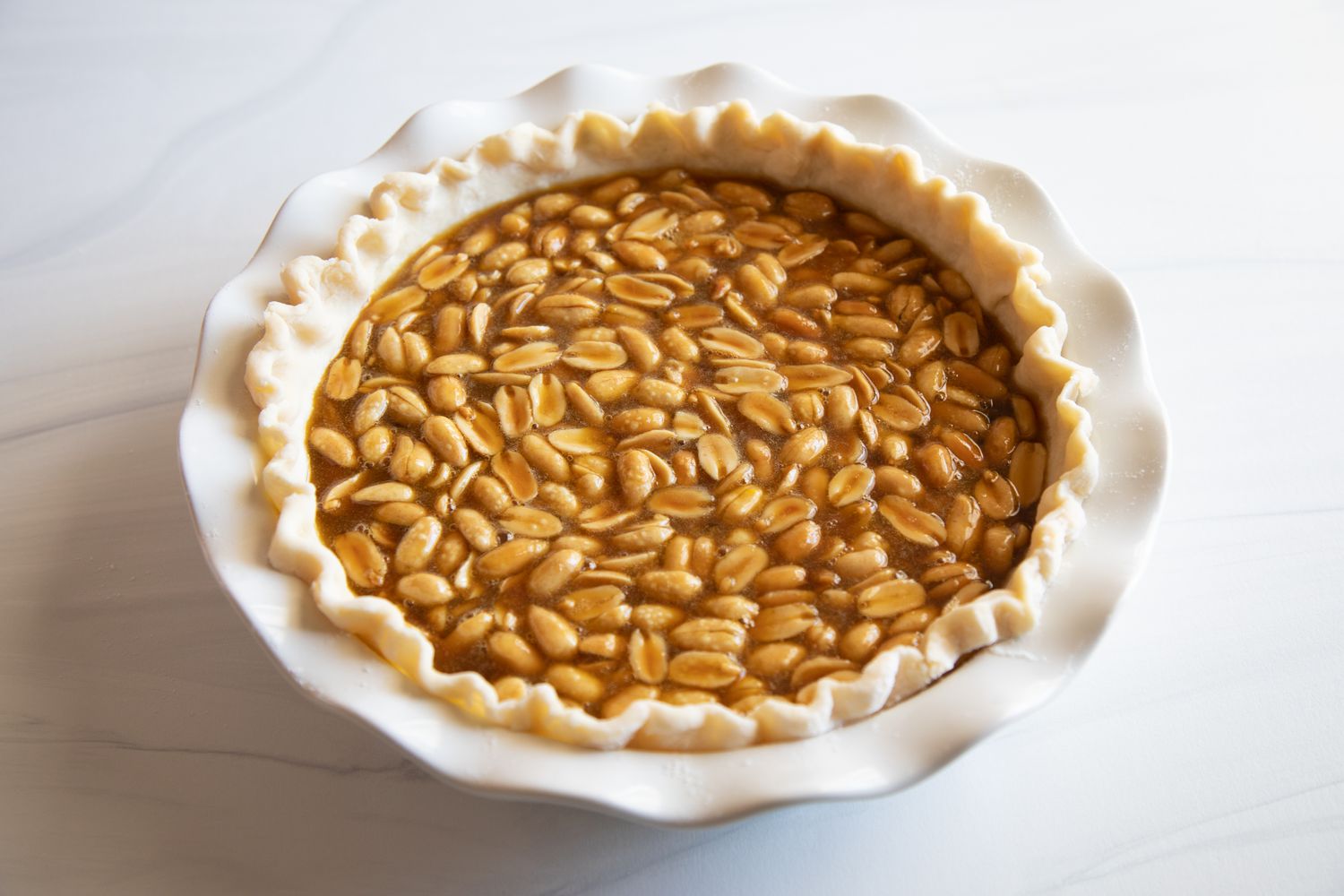 Filling in pie crust and ready to be baked for a Southern Peanut Pie.