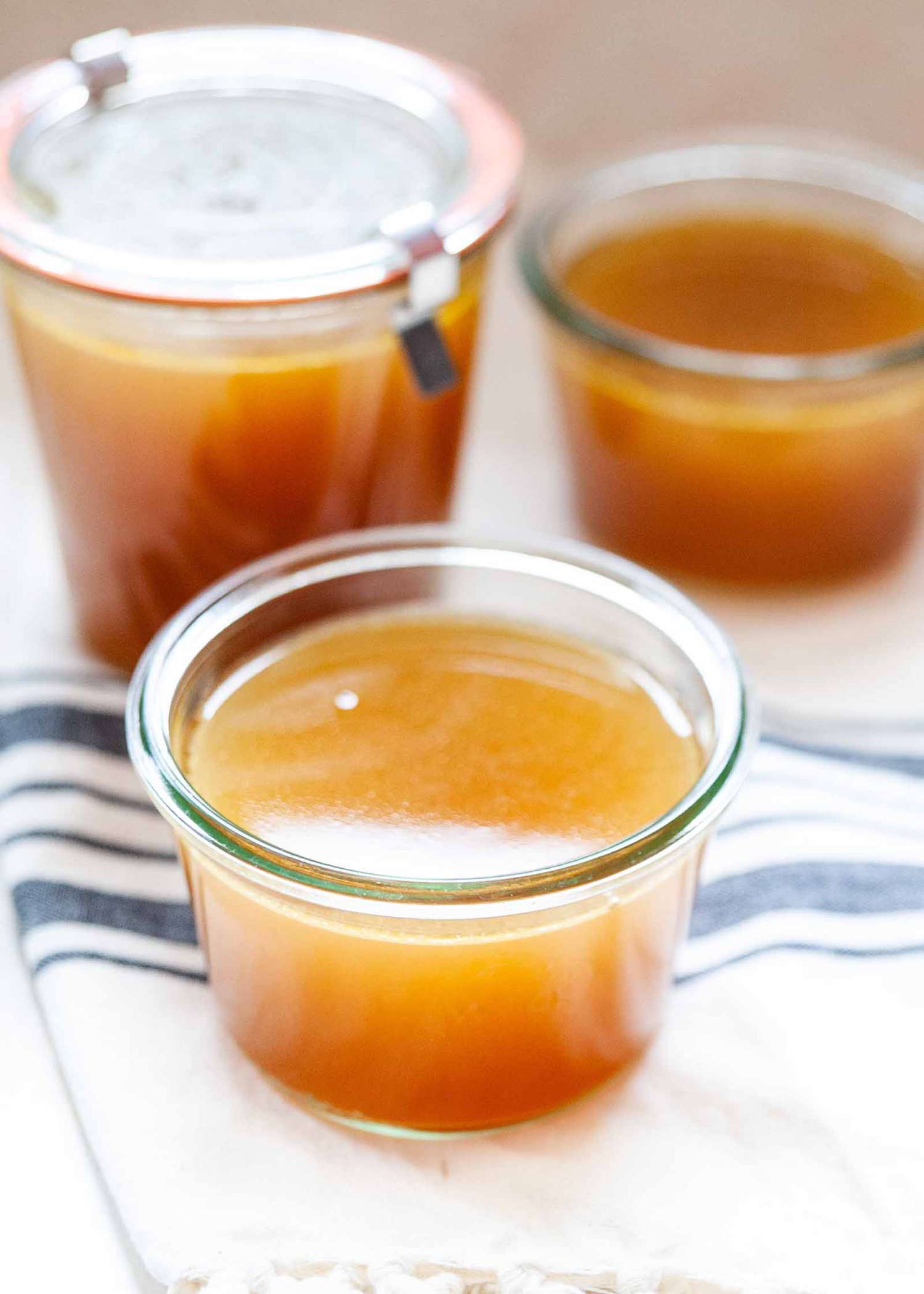 Turkey stock with leftover bones in glass containers.