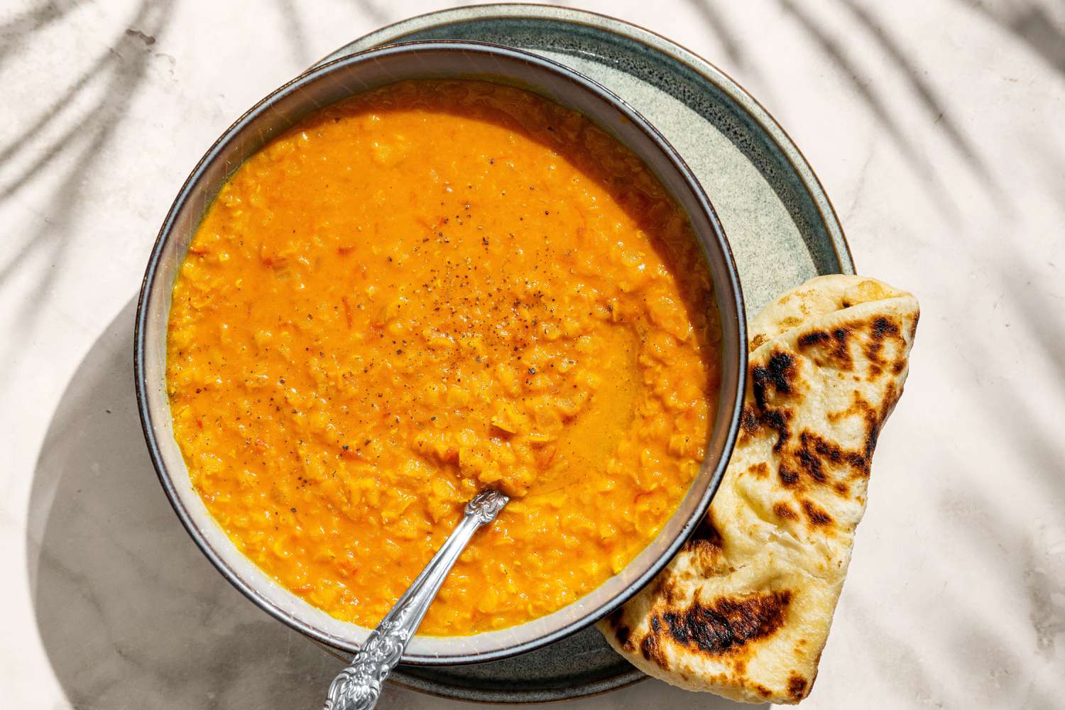 Coconut Lentil Soup in a bowl with naan on the side