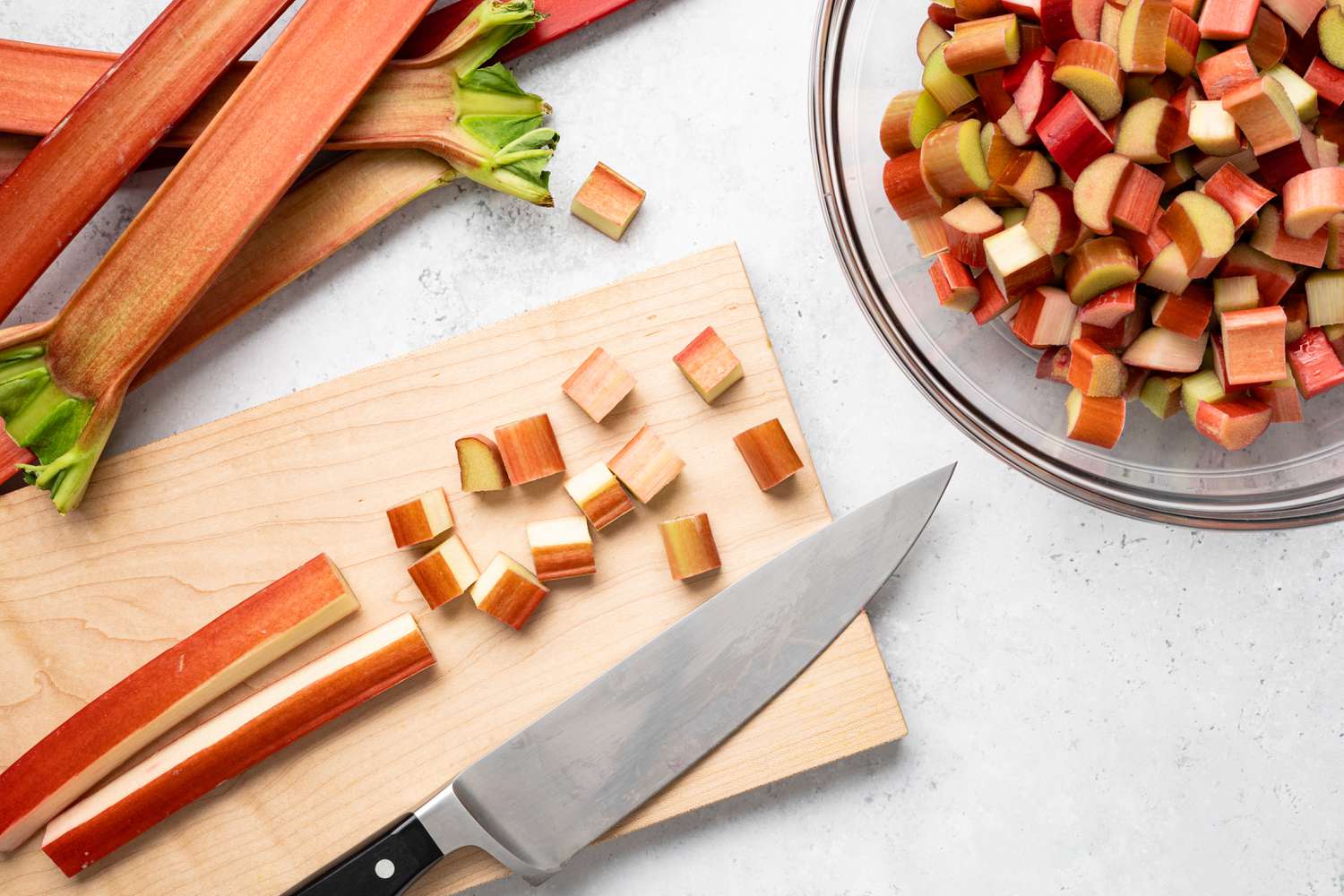Rhubarb Cut into Pieces on Cutting Board Next to a Bowl Full of Cut Rhubarb for Pie