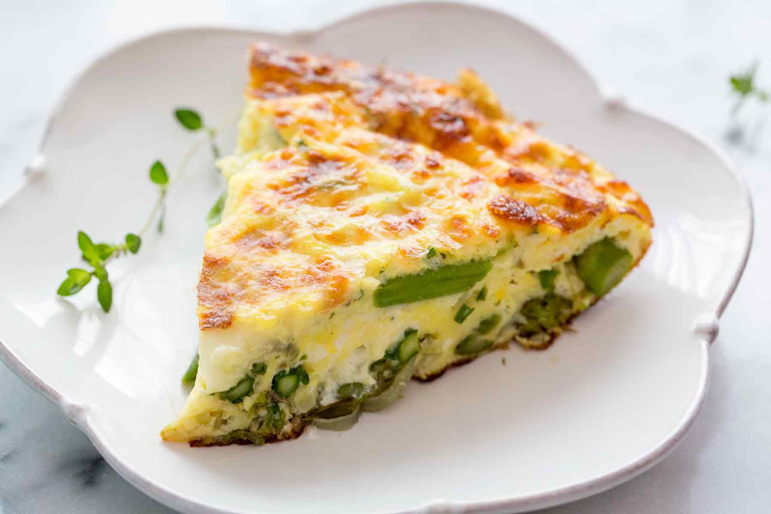 A slice of asparagus frittata on a serving plate