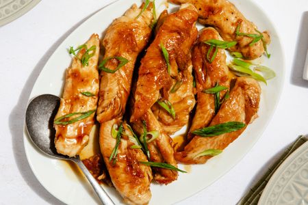 hot honey tenders on a platter with a serving spoon