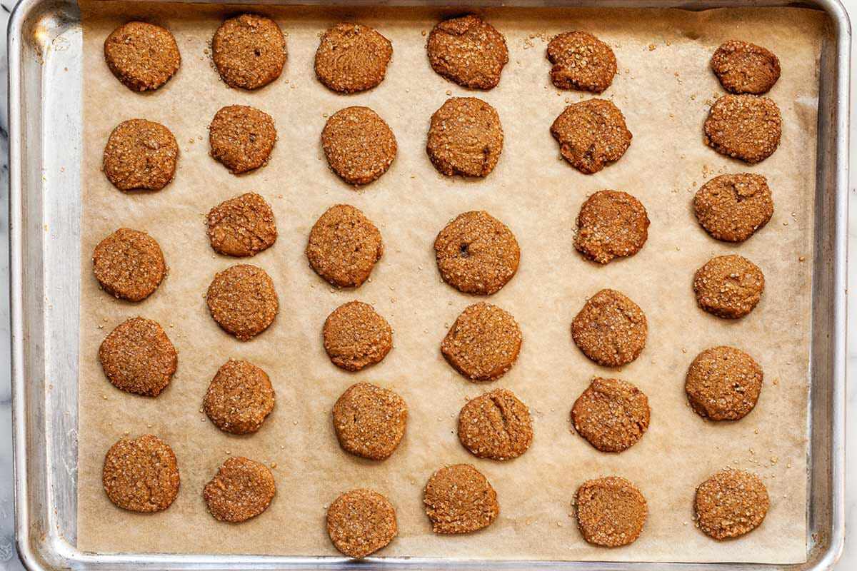 Slice and Bake Ginger Cookies cooling on a baking sheet covered with parchment.