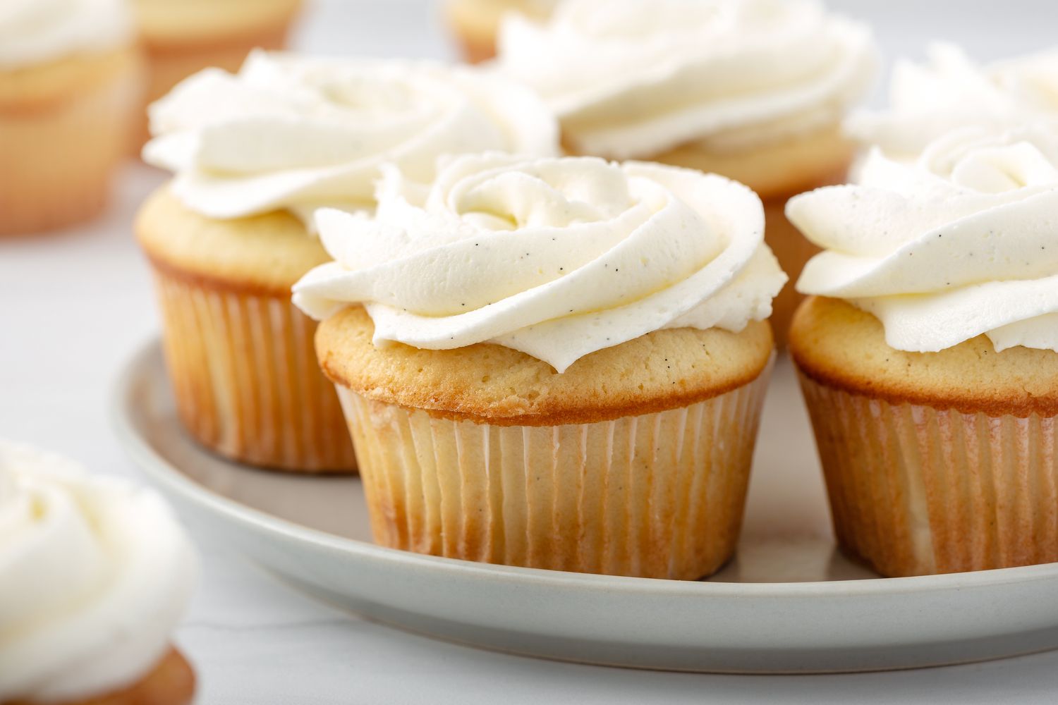 Side view of a platter of vanilla cupcakes.