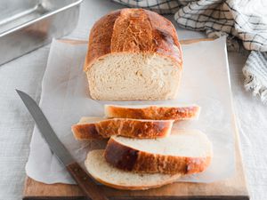 On Parchment on a Cutting Board, Slices Cut from a Sourdough Sandwich Loaf Next to the Remaining Loaf
