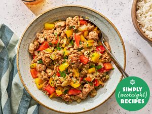 Ground turkey and peppers in a grey bowl with a spoon and white rice on the side in a brown bowl