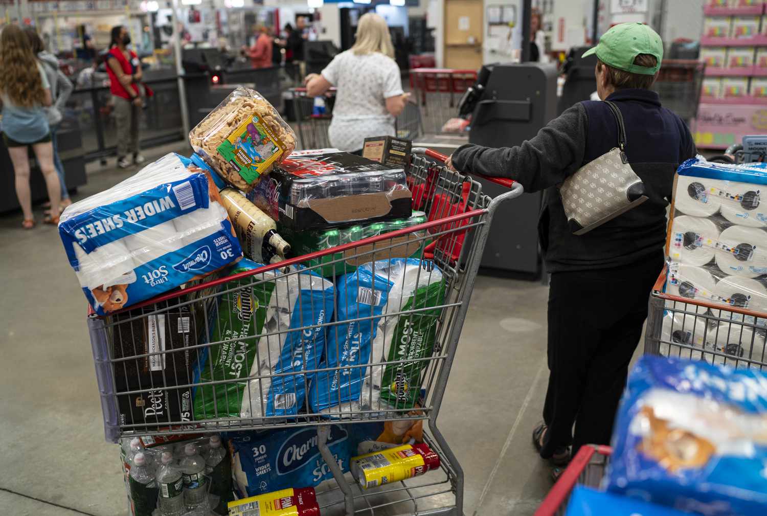 Woman holding a filled Costco shopping cart
