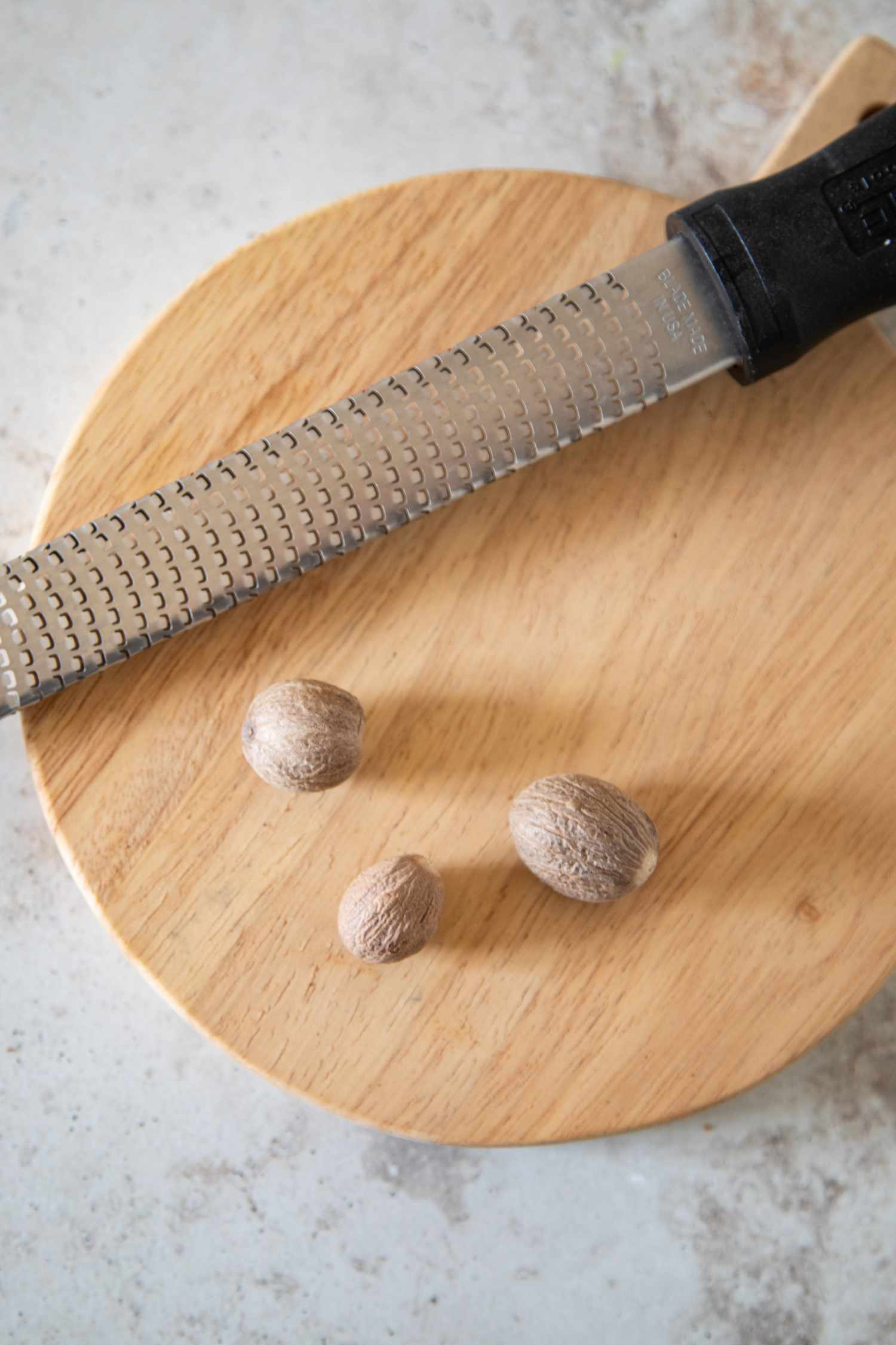 Whole nutmeg next to a microplane grater