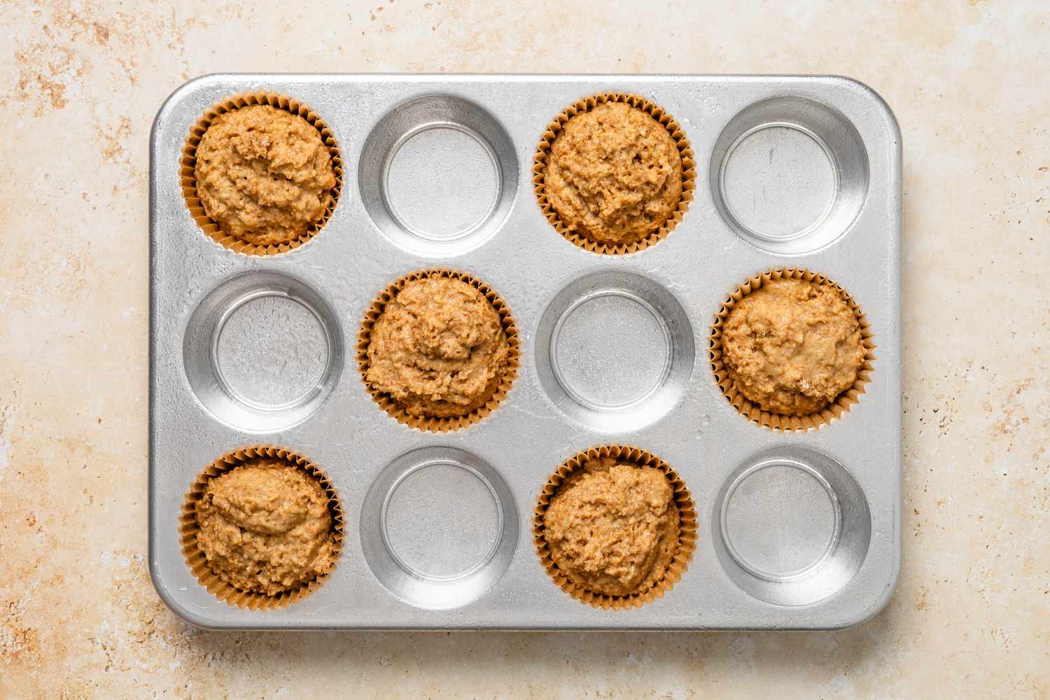 Bran muffin batter added to lined muffin tray 