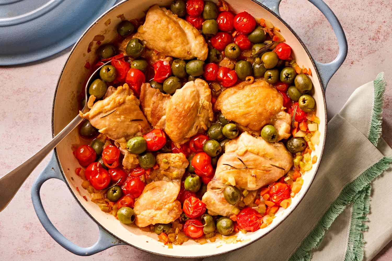 Overhead view of a blue dutch oven of tuscan-style chicken thighs recipe