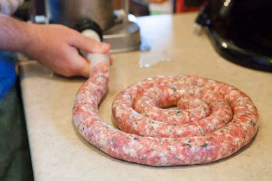 Hand shaping homemade sausage on a countertop
