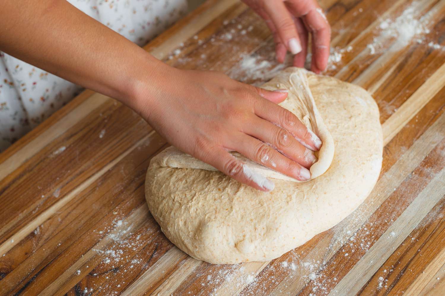 Shaping dough on a counter to make spiced sourdough bread shaped like a pumpkin