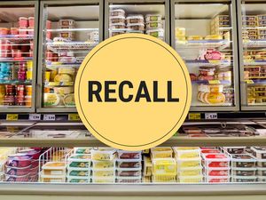 Supermarket freezer section with recall notice over packaged food items